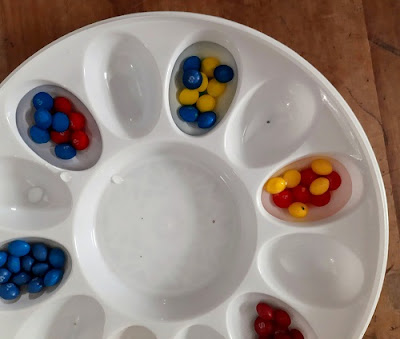 Red, yellow, blue Skittles soaking in water