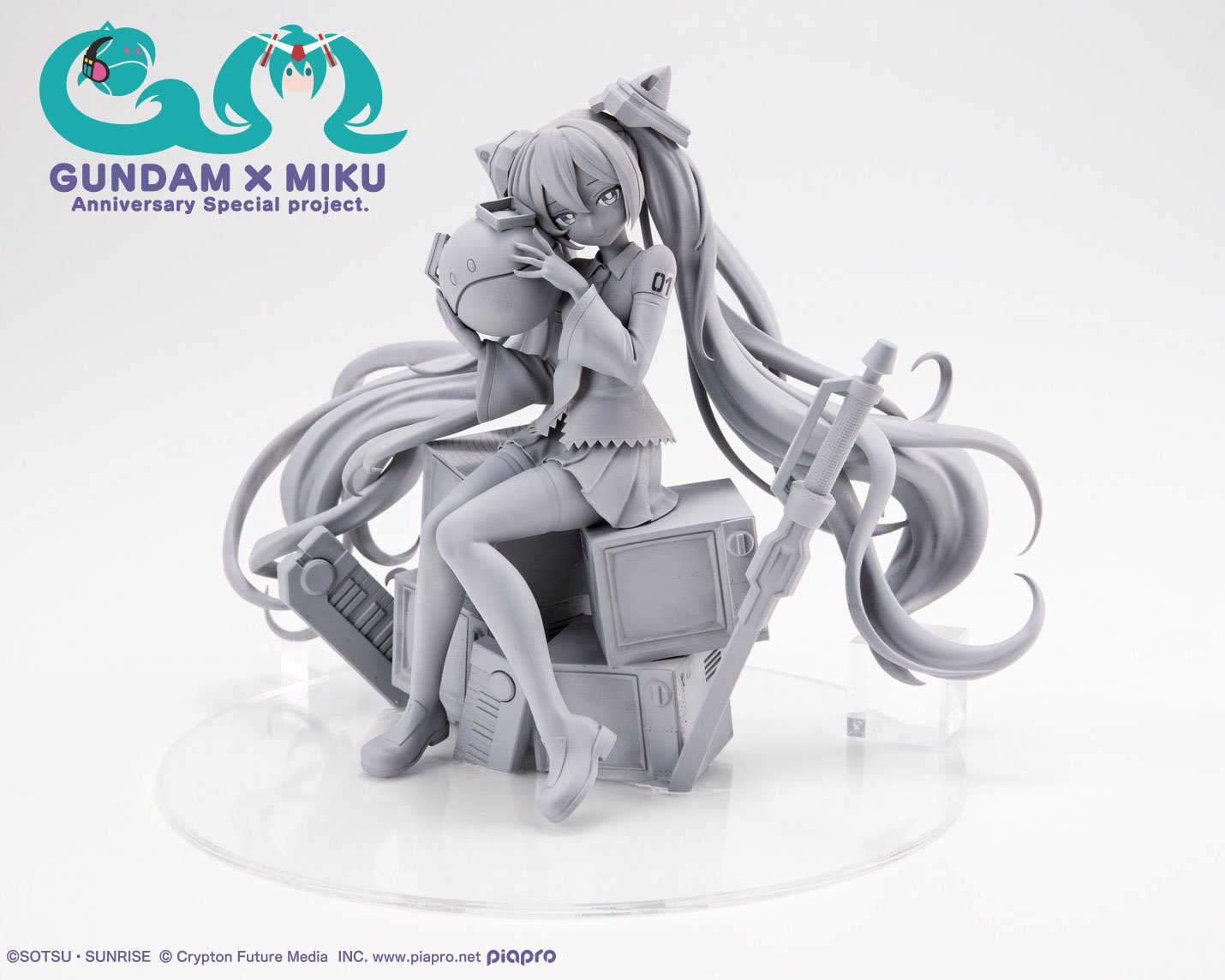Gray prototype of Miku sitting, hugging a Haro, surrounded by mechanical parts.
