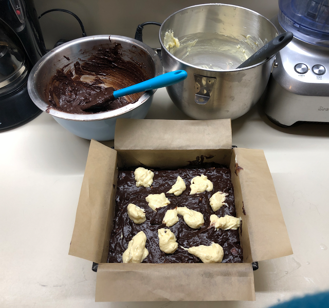 First layers of peppermint brownie batter with dollops of peppermint cheesecake batter