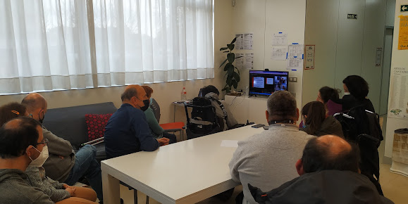 Personas conectadas a través de la televisión a una videoconferencia.