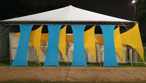 Decoração em malha tensionada em dois formatos, triangular e retangular cor amarelo, posição horizontal e retangular a frente vertical cor azul., frente Espaço Vip 