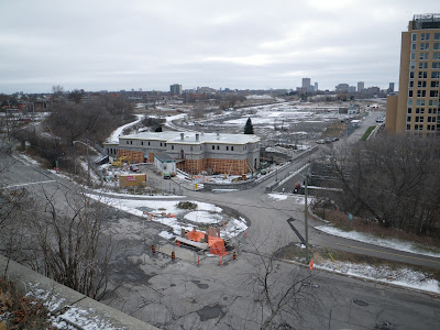 December 2012. Looking from the park atop the cliff at Bronson and Sparks down to LeBreton Flats including old Wellington Street, Pooley's Bridge, and Fleet street. Water pumping station is undergoing repairs. Condos south of Fleet not yet started construction. Transitway, no Booth Street bridge yet. A light dusting of snow.