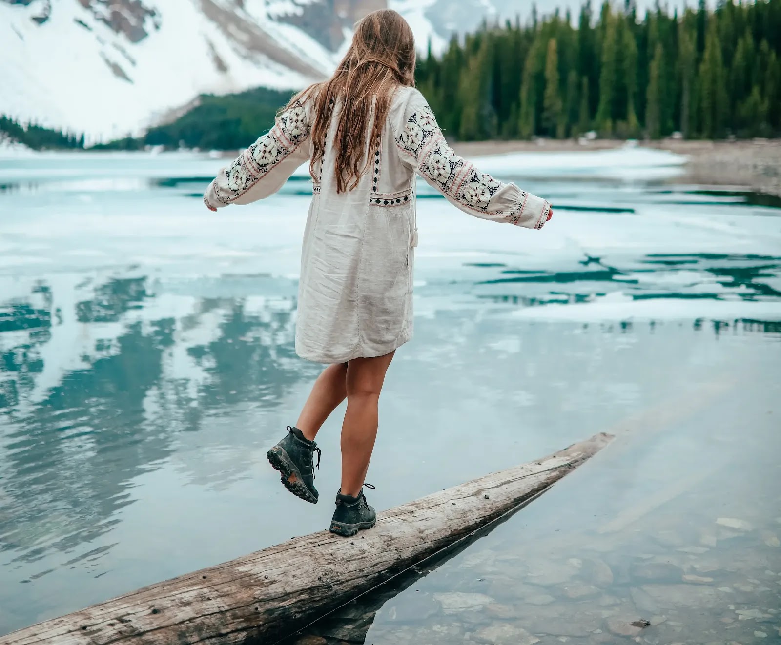 The image contains a woman walking on a log to explore herself.