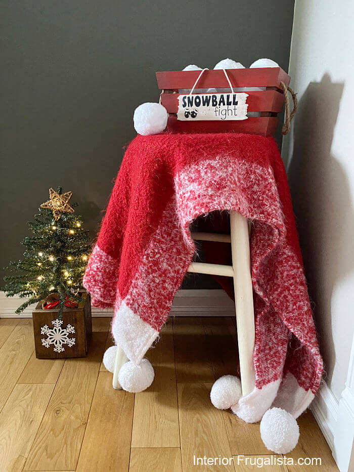How to turn a small natural wood crate into a fun indoor snowball fight holder Christmas and winter decor made with inexpensive dollar store finds.