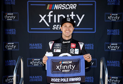 Trevor Bayne, driver of the #18 Devotion Nutrition Toyota, poses for photos after winning the pole award during qualifying for the NASCAR Xfinity Series United Rentals 200.