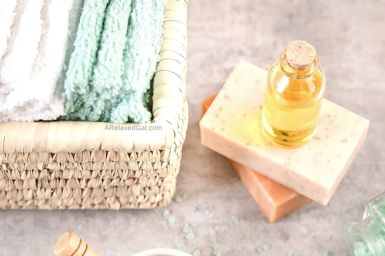 self-care kit with wash clothes in basket next to body oil and body soap bars.