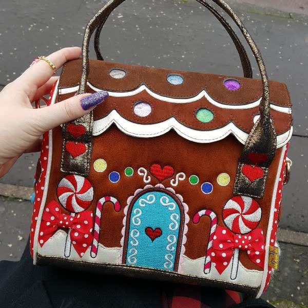 bag shaped like gingerbread house sitting on lap