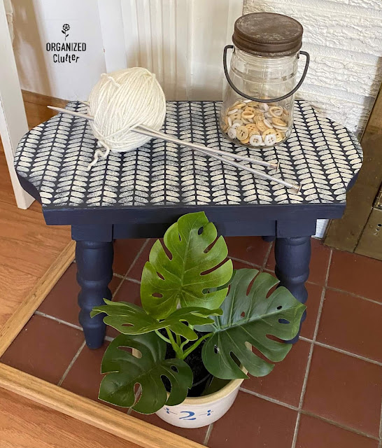 Photo of a navy chalk painted stool stenciled with a cable knit cozy sweater stencil.