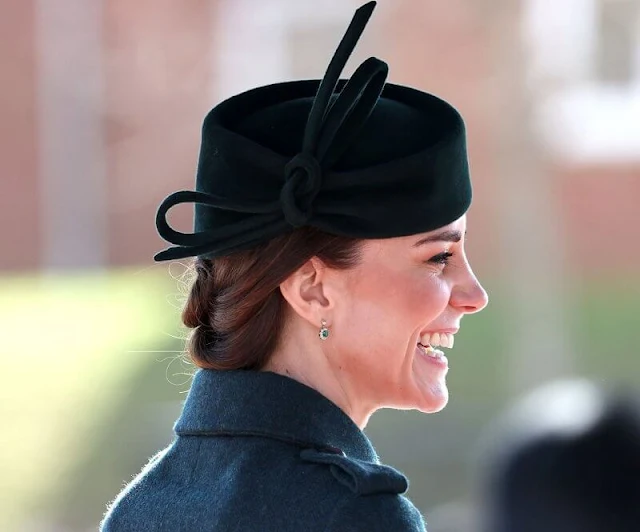 The Duchess wore a new Emilia green coat by Laura Green London. Cartier Shamrock Brooch and diamond and emerald earrings