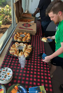 man getting pizza from a table