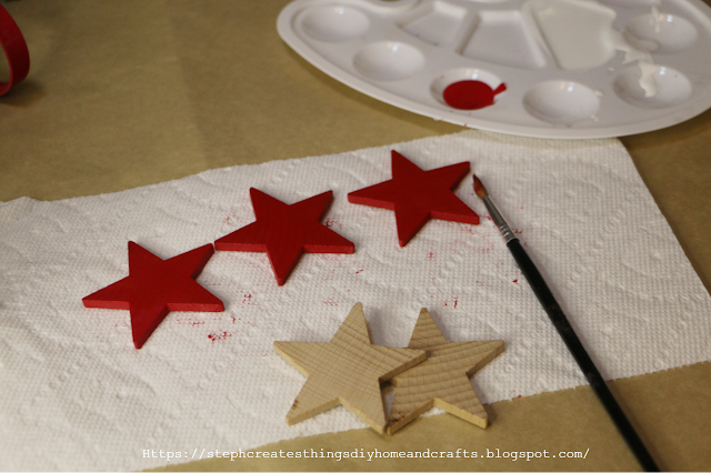 Three painted red wooden stars