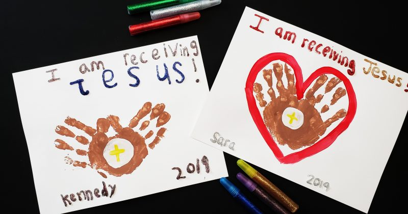 First Communion banner with handprints