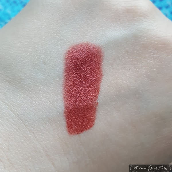 swatch on pale skin of MAC Powder Kiss Lipstick in Brickthrough