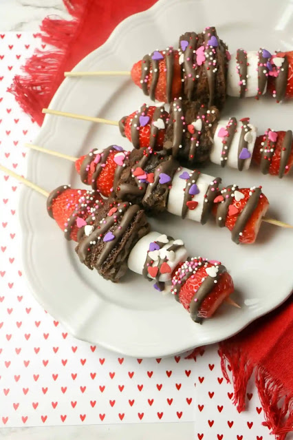 dessert sticks on white platter with heart background.