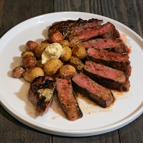 NY Strip Steaks with Roasted Garlic Butter cooked on the Big Green Egg Mini-Max