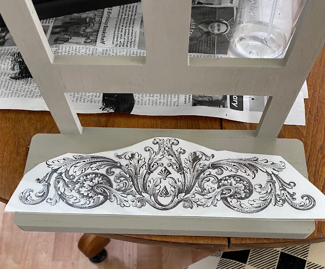 Photo of a decor transfer being added to the seat of a Target chair shelf.