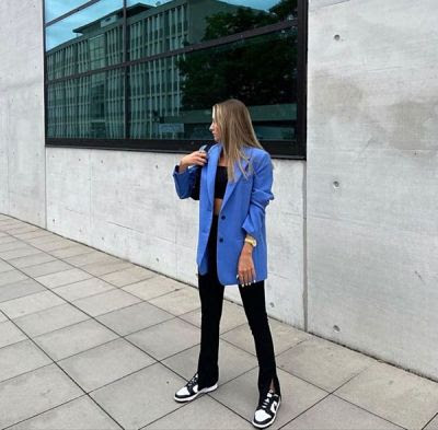 Mujer en look con blazer y tenis