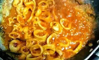 Cooking squid fry on a tawa