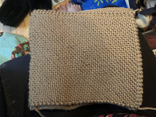 A rectangle of bias knit garter stitch in tan yarn.