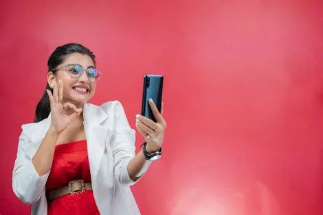A girl in pink dress is doing whatsapp video call and smiling