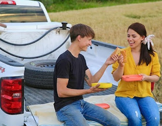 Molly Yeh sitting outside the jeep & sharing food with her spouse Nick