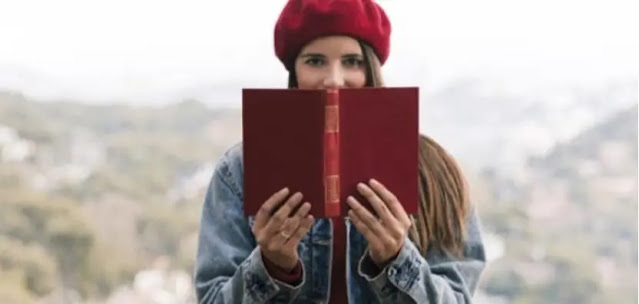 A lady is holding a book
