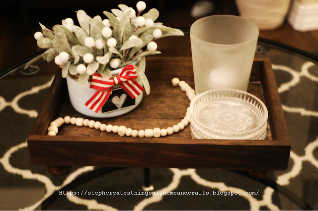 faux winter floral inside of painted blue candle jar, with mini chalkboard and bow. Displayed on wooden tray