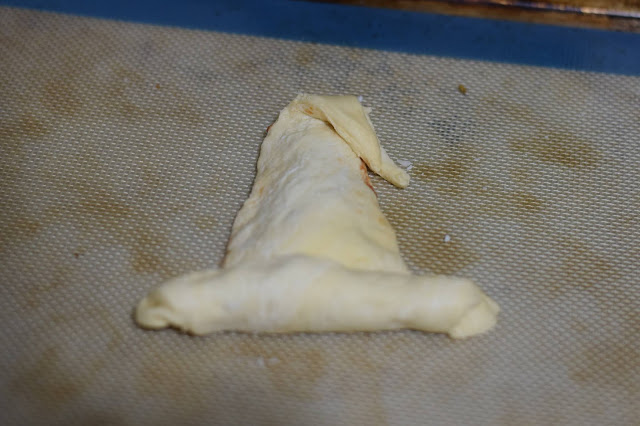 The tip of the witches hat folded down and the bottom rolled up to form a brim.