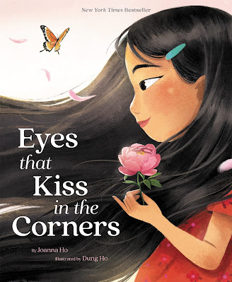 Cover for the children's book, Eyes That Kiss in the Corners. A little Chinese girl in profile holds a pink flower and looks at an orange butterfly.