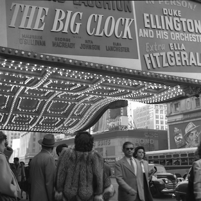 black and white 1948 photograph of The Paramount Theater marqee with well-dresses people walking by, New York