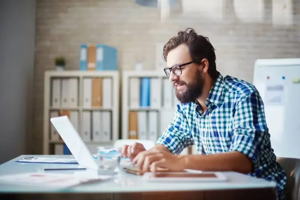 travail de blogueur homme écrivant sur son ordinateur portable