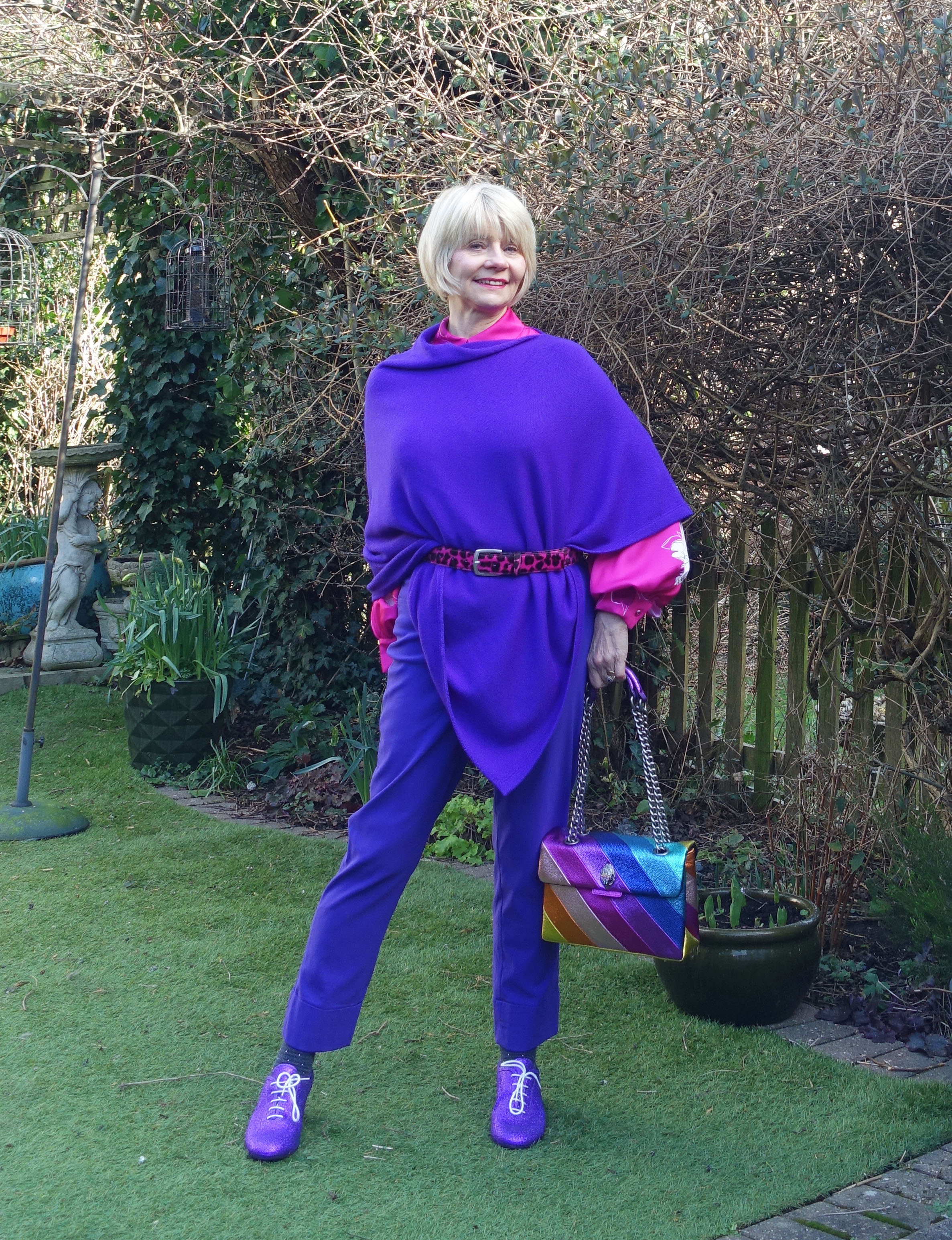 Gail Hanlon belts a purple poncho and styles it with a rainbow bag and bright pink blouse