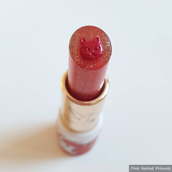 close up of lipstick with red cat face in centre and glitter transparent surround