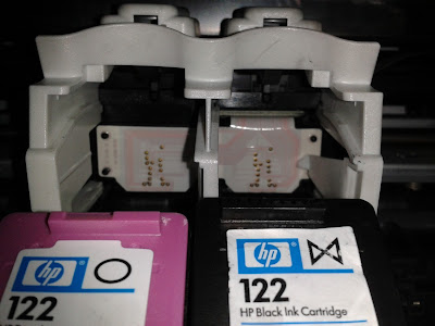 Cartuchos de tinta HP 122 negro y tricolor a punto de colocarse en la impresora HP.