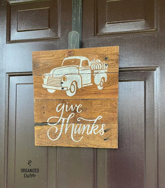 Photo of a Goodwill rustic photo holder stenciled as a fall truck front door sign.