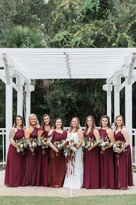 bride smiling with bridesmaids in burgundy dresses