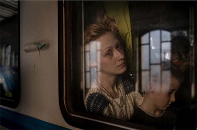 photograph through train window of woman and her son leaveing Ukraine for  for Poland