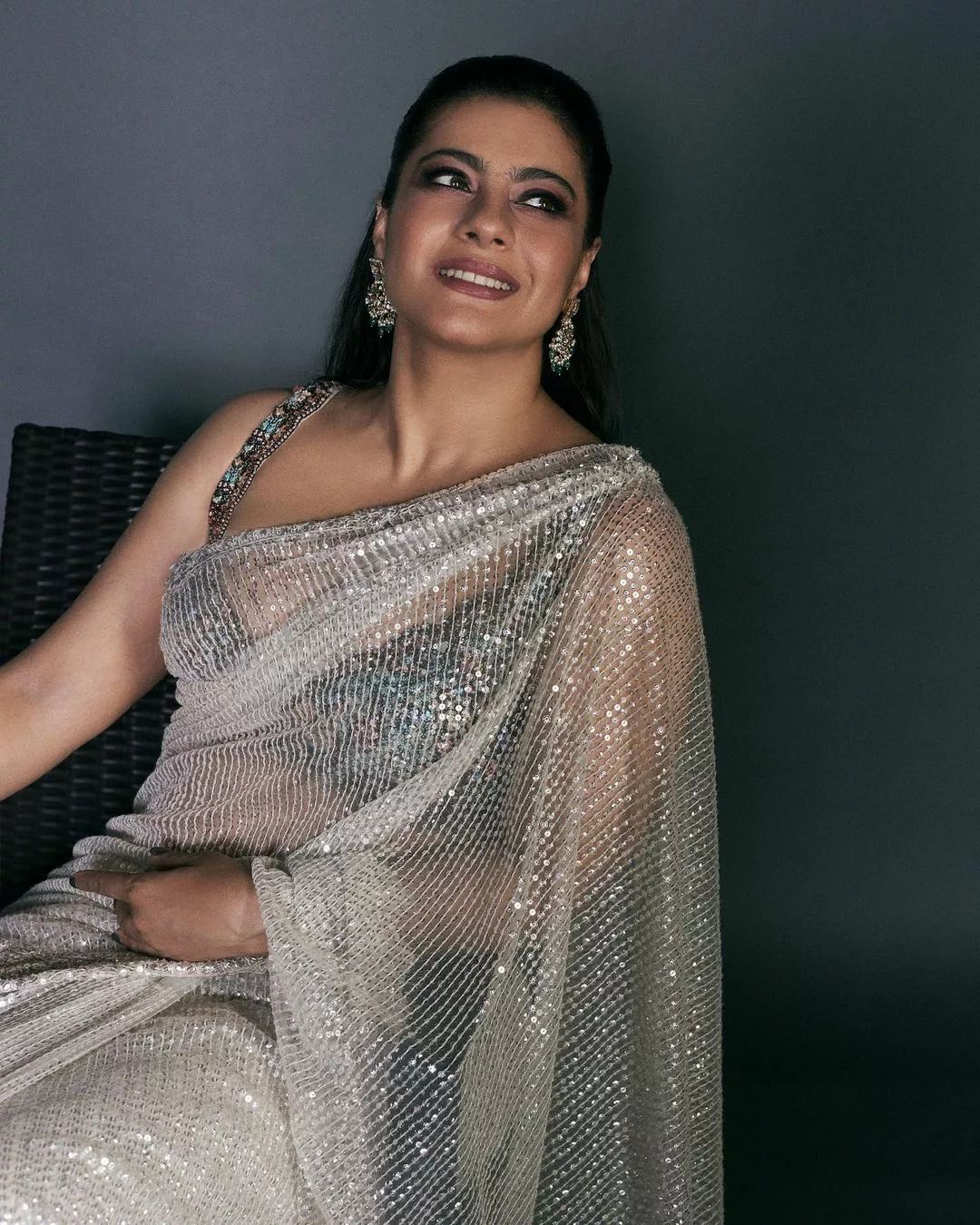 "Bollywood actress Kajol Devgan wearing a sleeveless sequin saree blouse with a plunging neckline."