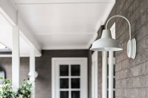 White metal barn light on gray house