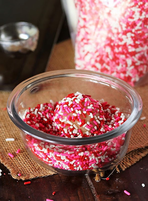 Rolling Dough Ball in Sprinkles to Make Valentine's Sprinkle-Coated Sugar Cookies Image