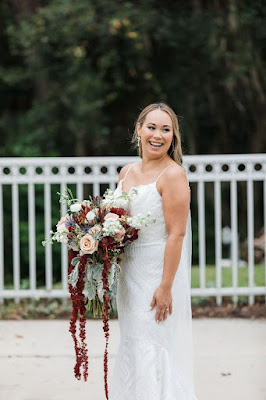 bride smiling with white and burgundy bouquet