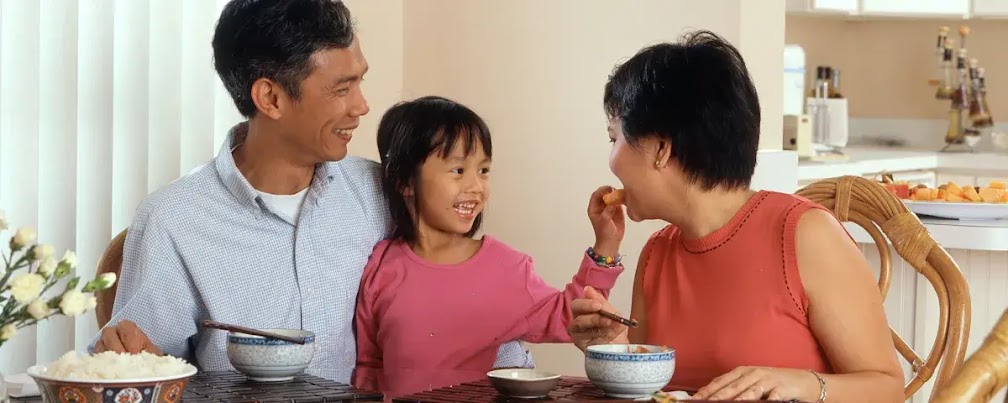食事をするアジア人の家族。父母と女の子。