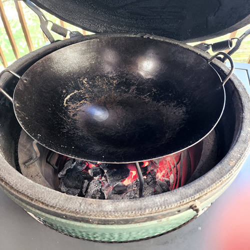 Carbon steel wok on a Big Green Egg kamado grill