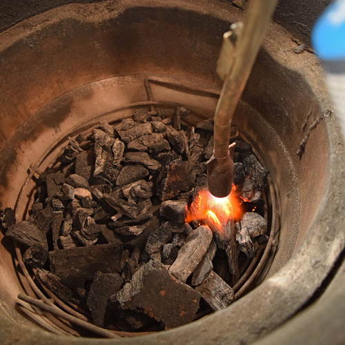 Using the JJ George Grill Torch to light a Kick Ash Basket full of lump charcoal