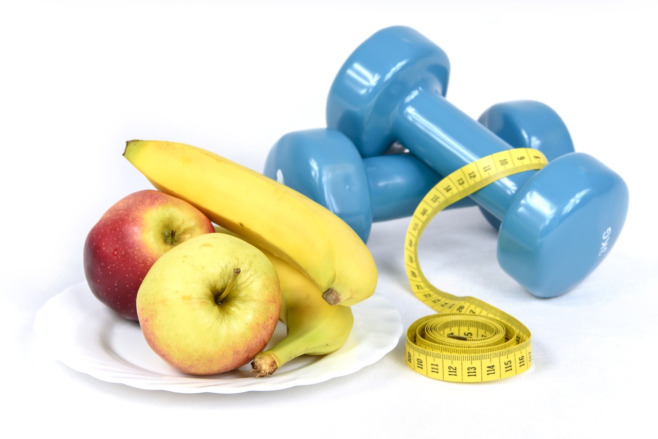 Healthy Lifestyle tips. The image contains apples, bananas placed on a plate, a measuring tape and dumbbells.