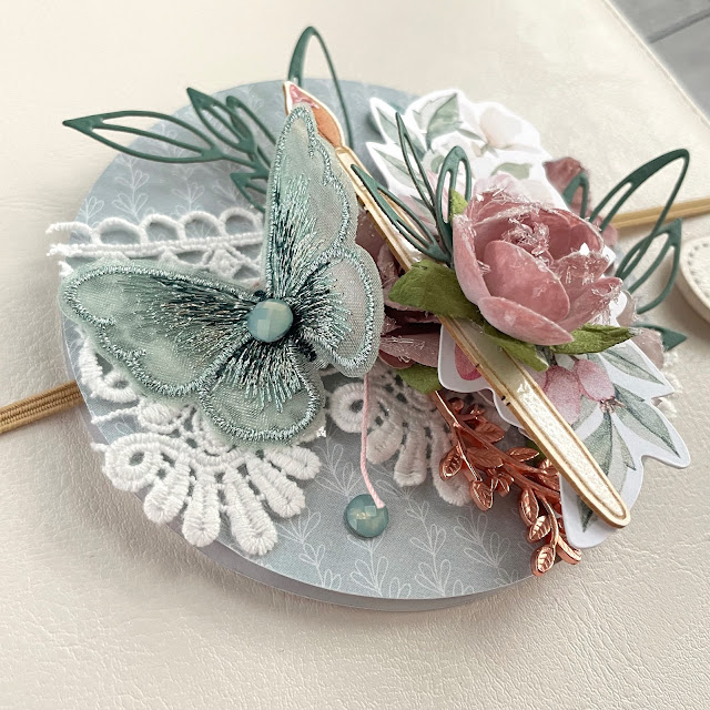 Mixed Media Planner Embellishment made with: P13 Let Your Creativity Bloom 6x6 paper, ephemera, light chipboard; Prima Marketing Sharon Ziv flowers, my sweet butterfly embellishment; Scrapbook.com smart glue, floral sprigs die cut; Tim Holtz kraftstock, distress ink; Reneabouqeuts lace, pale pink glitter glass