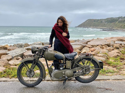 Woman with restored Royal Enfield motorcycle.