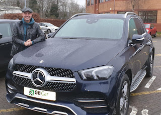 Kisty's hubby Jason Williams posing for photo with a car