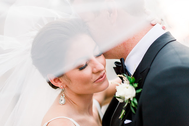 bride and groom under veil