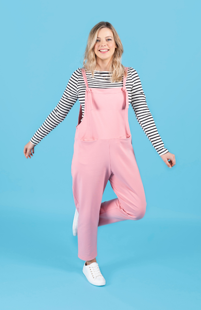 Model wearing long dungarees or overalls handmade using the Erin sewing pattern in stretch knit fabric